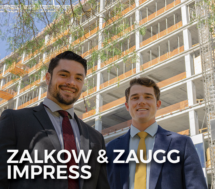 Finch, Thornton & Baird, LLP 2022 Summer Associates Nick Zalkow and Brody Zaugg standing in front of new construction next to our offices.
